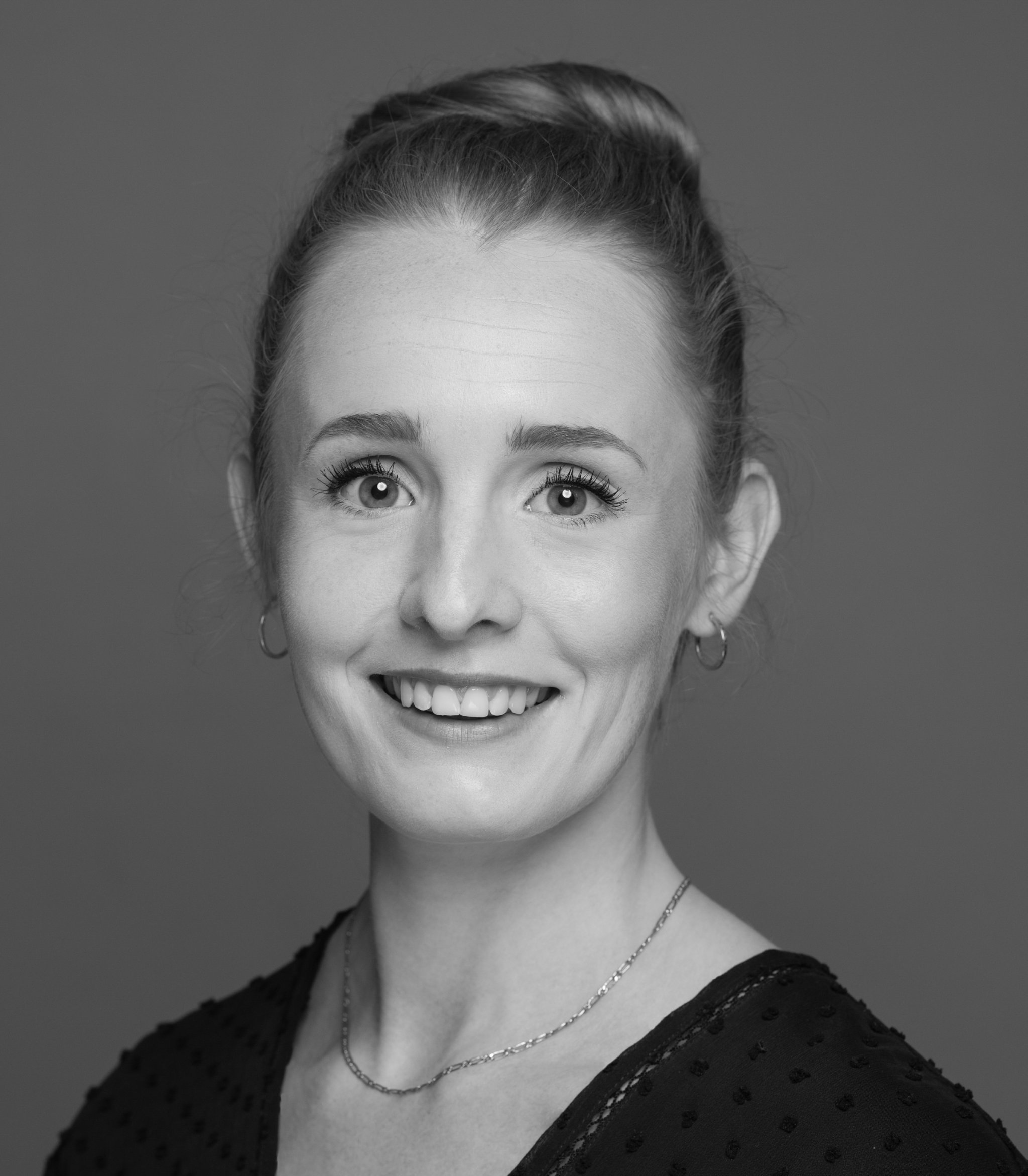 A black and white colourised headshot of Amelia O'Hara. Photographed by Tina Frances